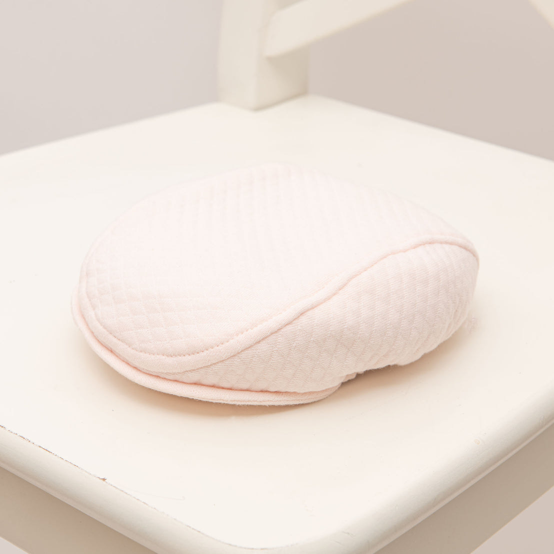 Flat lay photo of the pink Asher Quilted Newsboy Cap. 