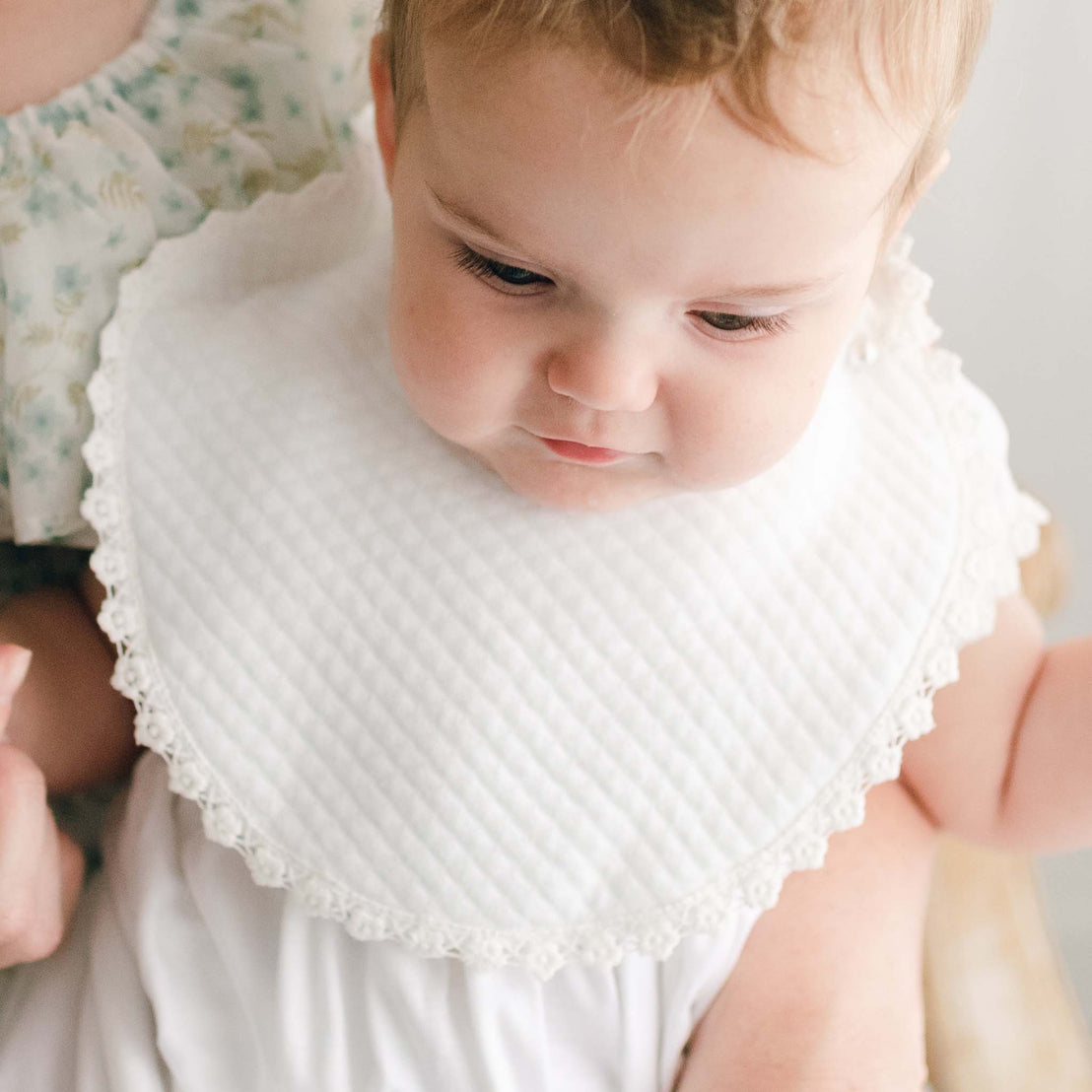 Baby wearing Ella bib lined with lace