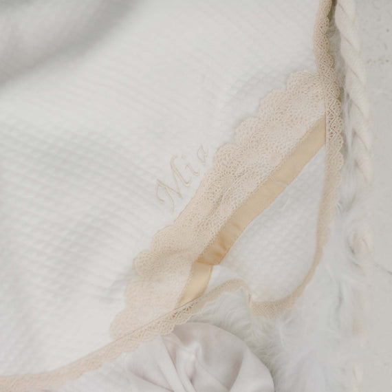 A close-up of the Mia Personalized Blanket with the name "Mia" embroidered in elegant script, set on a soft, textured background.