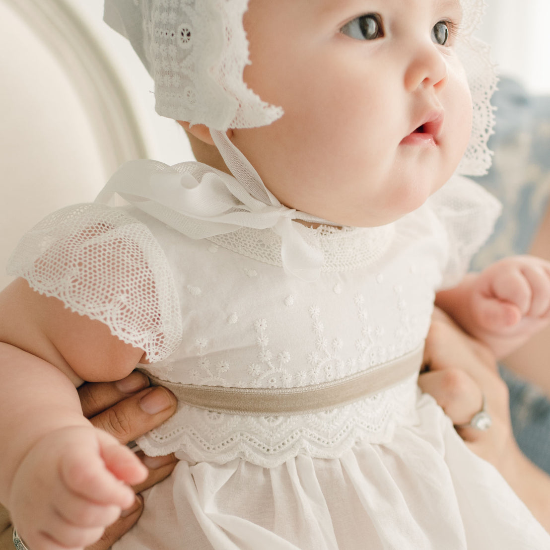 Close up of baby girl wearing the Emily Dress and Bloomers with tan sash.