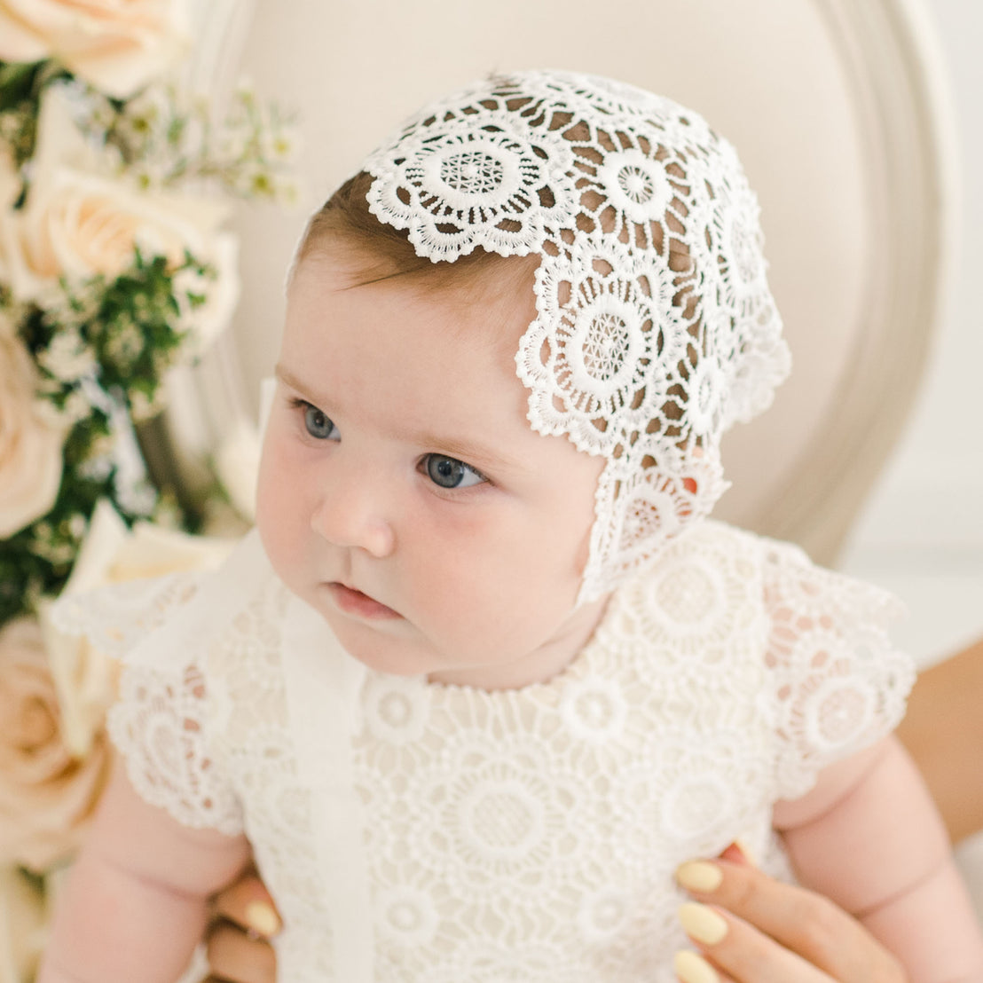 Close up photo of baby girl wearing her cotton lace baby bonnet.