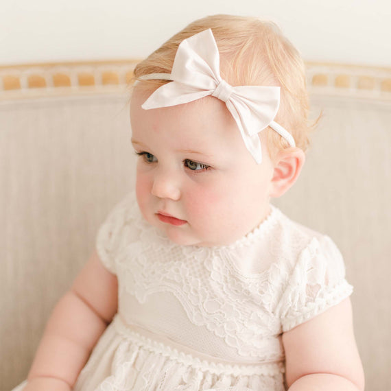 Baby girl wearing the Victoria Christening Headband in Pink.