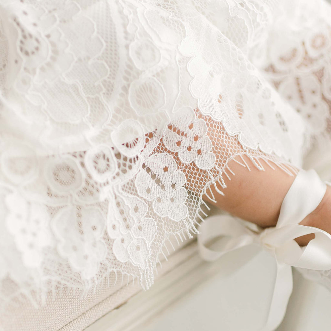 Close up detail of the hem of the Victoria Puff Sleeve Christening Gown in Ivory.