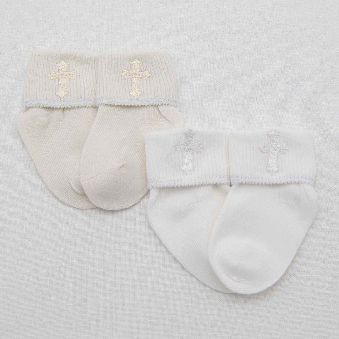 A pair of white Cross Socks with decorative lace and an embroidered cross, displayed on a plain light background.