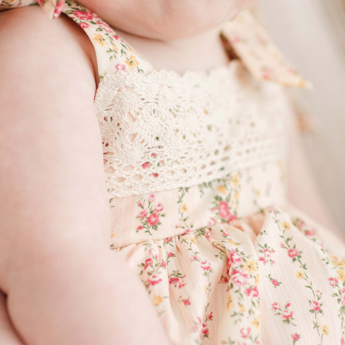 Detail of the Eloise Romper Dress in the color "Blush" and showcasing the natural toned lace trims.