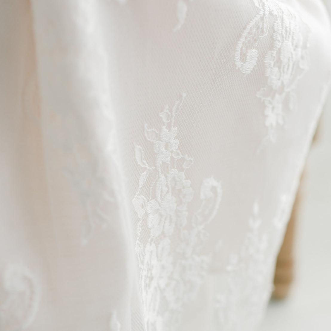 Close-up of the Juliette Christening Gown & Bonnet, showcasing detailed texture and upscale craftsmanship.