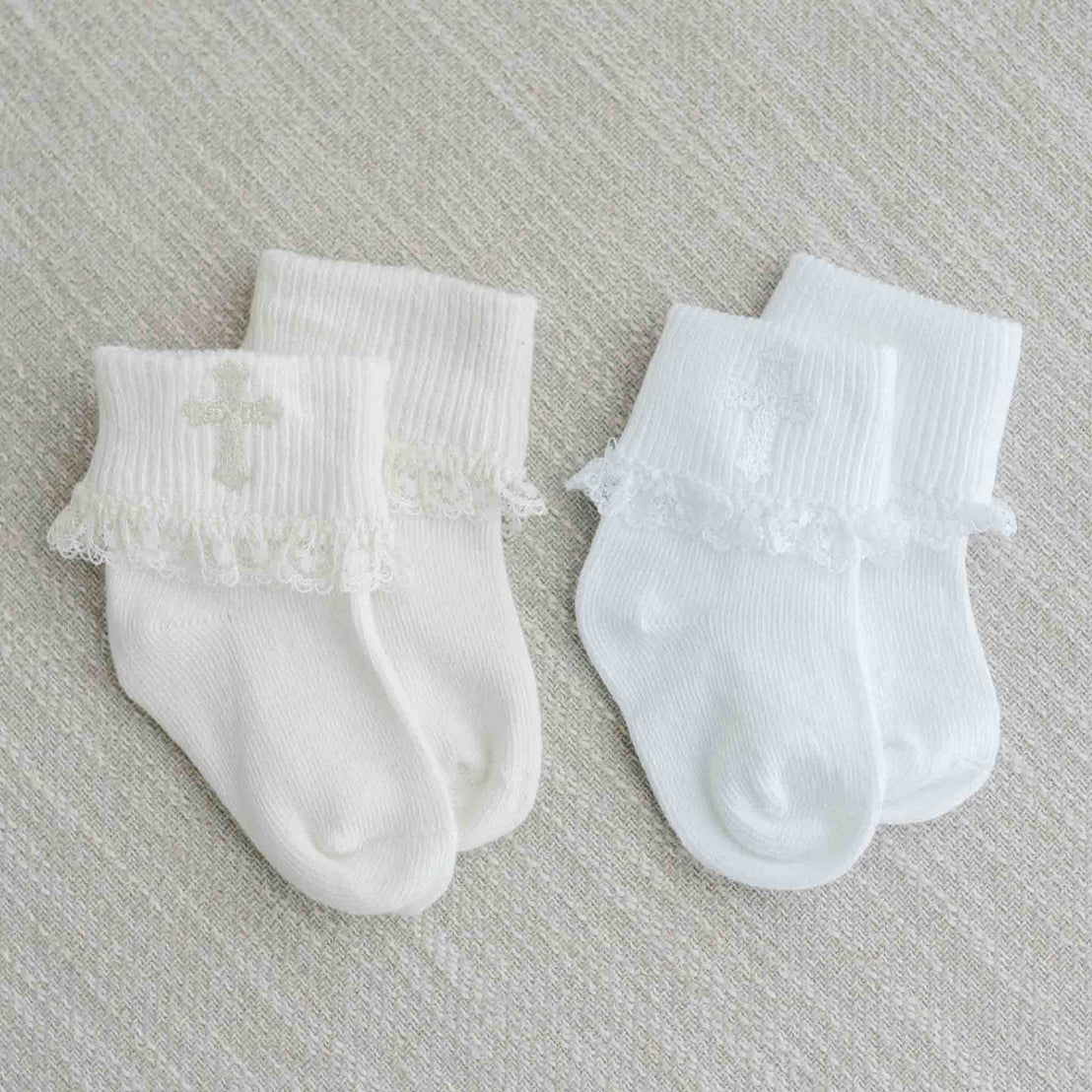 Two pairs of white Lace Cross Socks, placed on a light gray textured background.