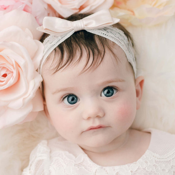 Baby Girl Closeup wearing the Victoria Lace Silk Bow Headband in Pink.