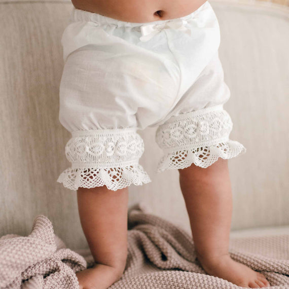 Baby wearing the Lily Bloomers made with 100% light ivory cotton, light ivory lace, and ivory silk ribbon