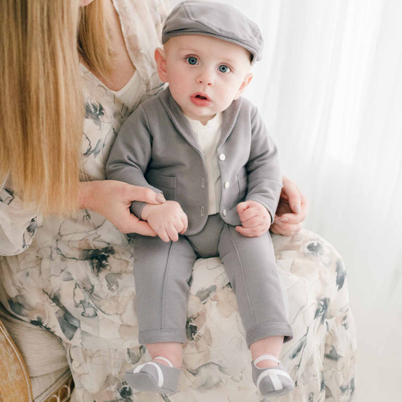 Baby boy sitting in mom's lap in grey cotton suit