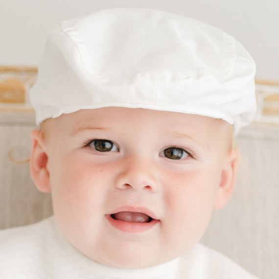 Baby boy wearing traditional newsboy cap made of linen.