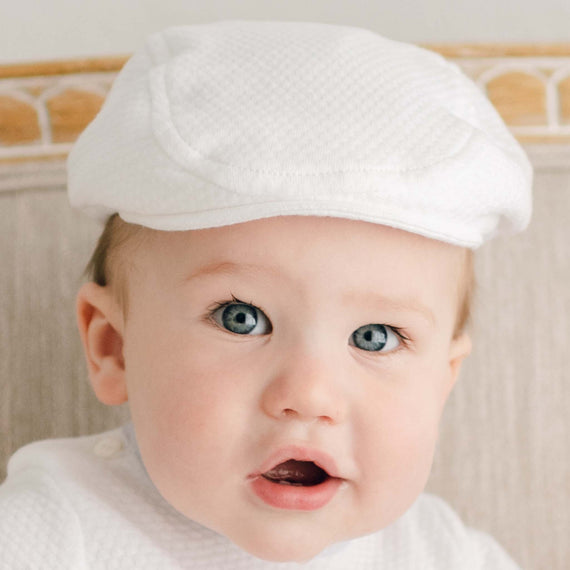 Baby boy wearing the Harrison Textured Newsboy Cap made with the same textured cotton. The newsboy style baby hat is finished with a soft elastic along the back to ensure a nice, comfortable fit