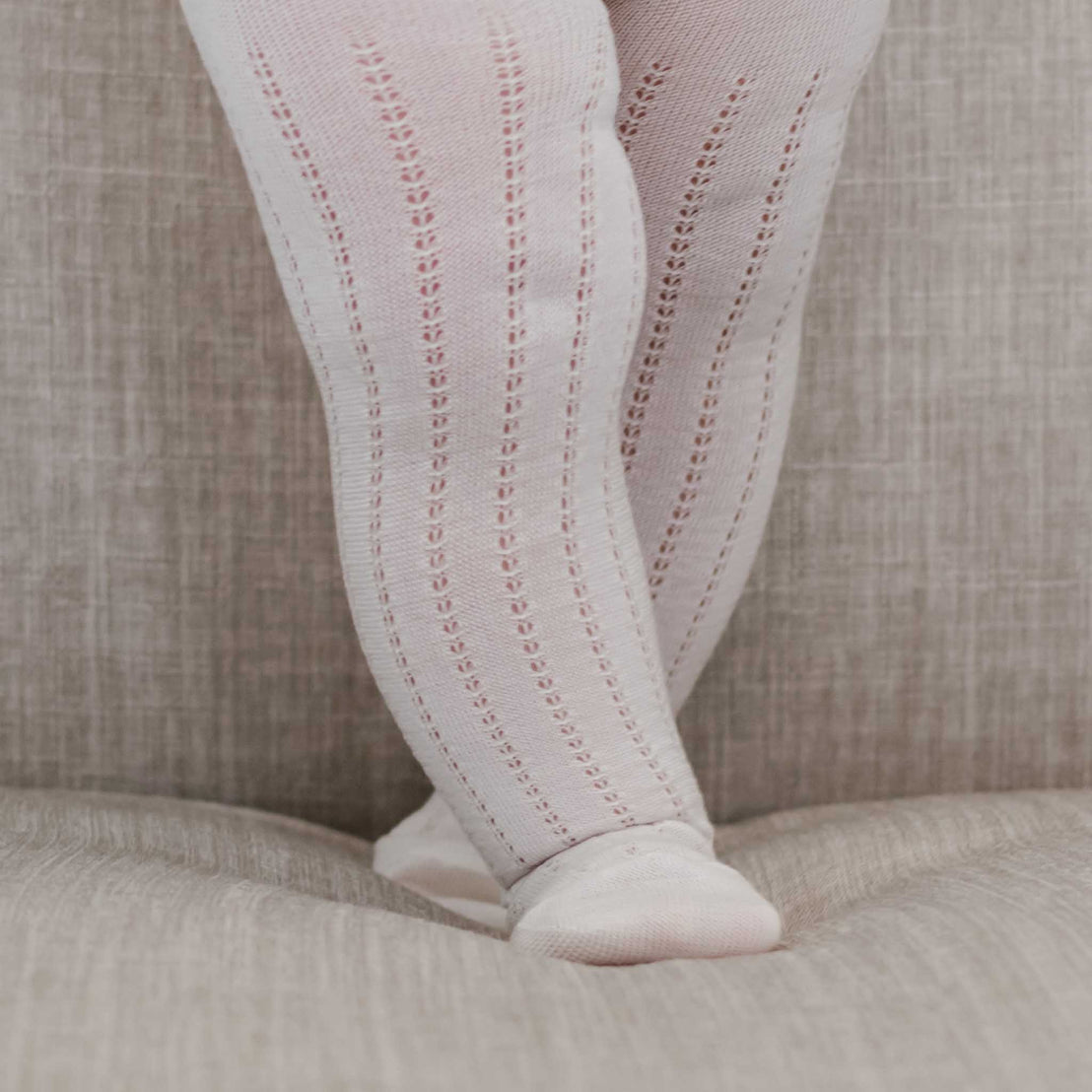 Close-up of a person wearing Openwork Fancy Tights and pointe shoes, standing on tiptoe, showcasing the detailed design of the tights and the refined fabric texture.