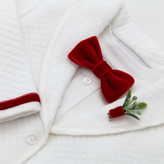 Close-up view of a white baby onesie, perfect for christening or baptism, embellished with a Noah Red Bow Tie & Boutonniere on the collar, set against an upscale white.