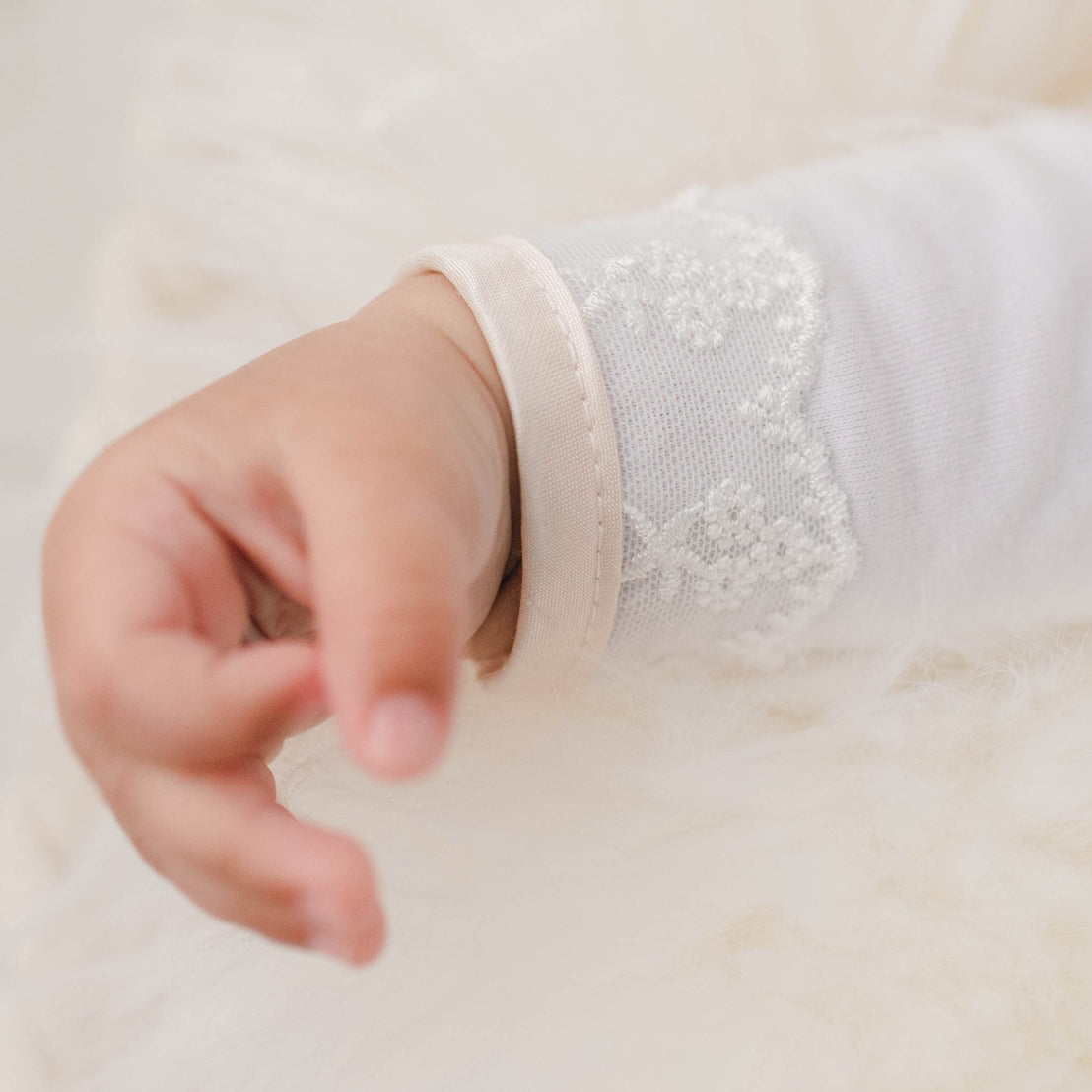 Close up photo showing the Tessa Quilt Newborn Gown sleeve hem.