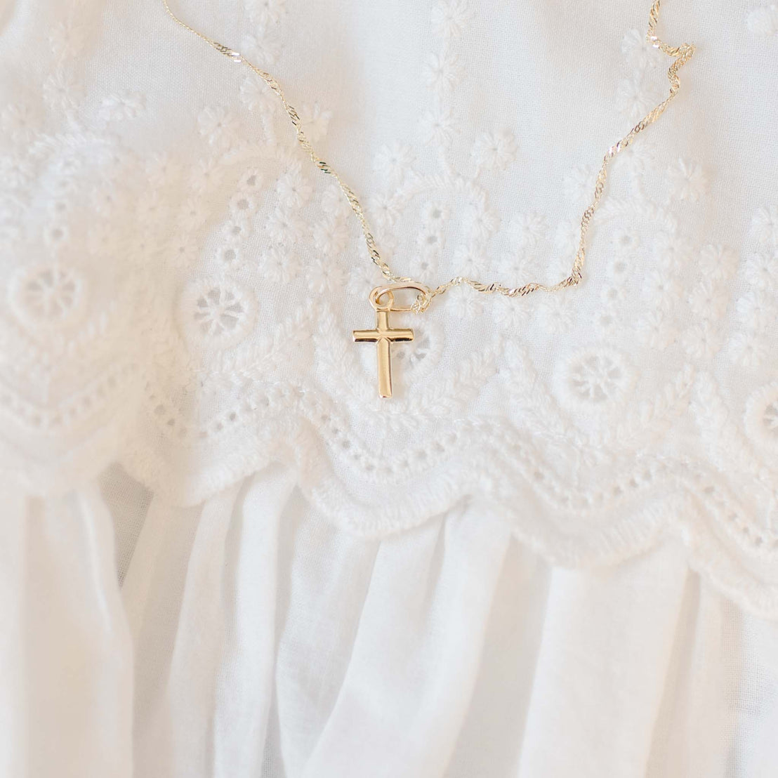 Small gold cross on baby