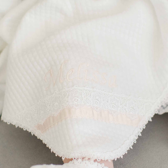 A softly textured white Melissa Personalized Blanket embroidered with the name "melissa" in elegant cursive, adorned with delicate lace detailing along the edge.