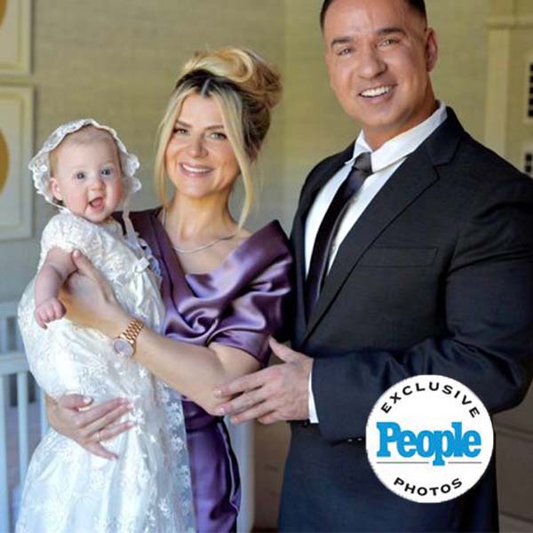 Lauren Sorrentino with Mick "The Situation" Sorrentino standing side by side with their daughter in a beautiful batpism gown. Photo featured in People Magazine with People logo in lower right hand.