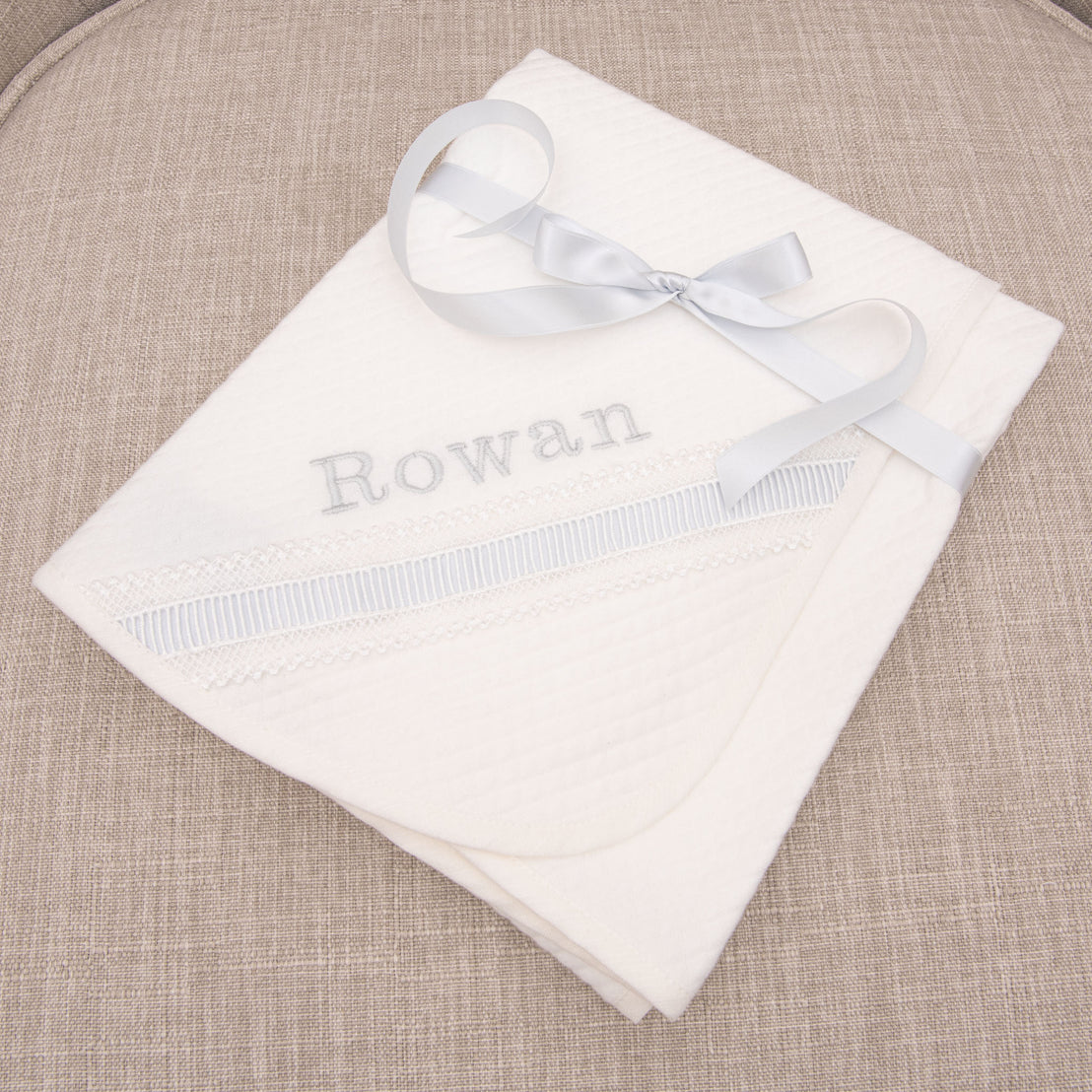 A personalized baby blanket wrapped with bow. 