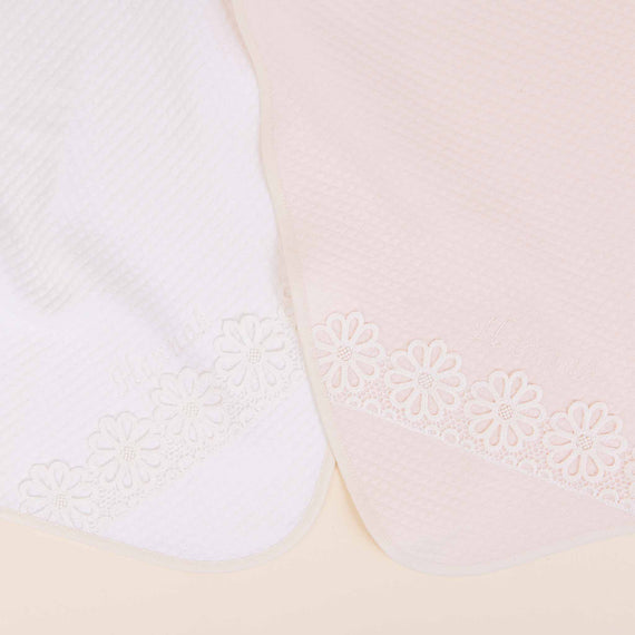 Two Hannah Personalized Blankets with embossed floral designs on a light beige background, one white and one peach-colored, highlighting texture and pattern details.