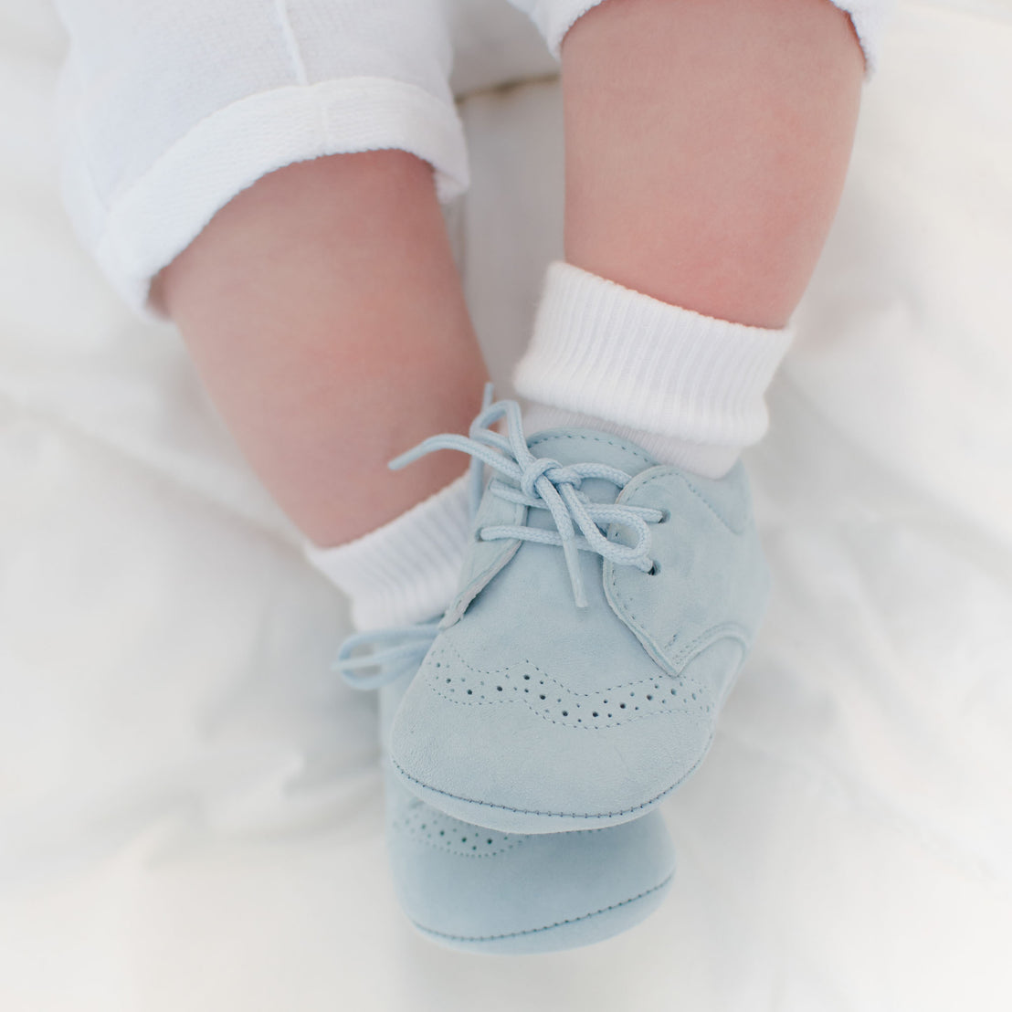 Baby boy wearing the Sky Blue Suede Shoes made from 100% Suede with detailed edging.