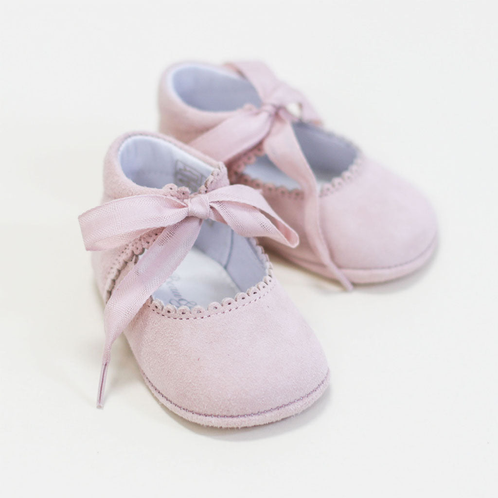 A pair of Blush Suede Tie Mary Janes, perfect for a christening, on a light background.
