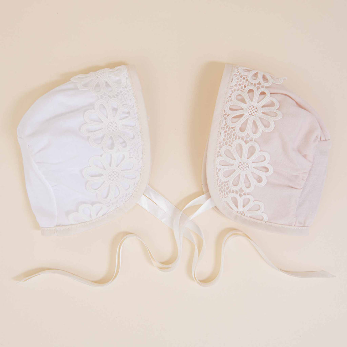 A delicate, lacy white bra with floral patterns displayed flat on a soft beige background, with its ribbons gracefully unfurled. This Hannah Newborn Gift Set- Save 10% offers a unique baby gift for the newborn.
