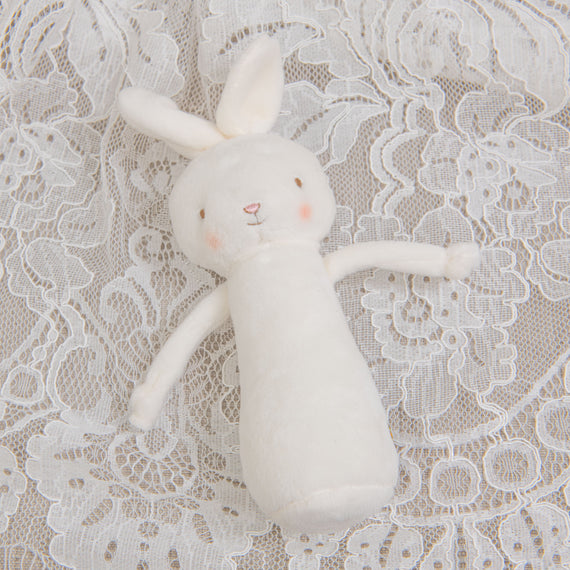 A flat lay photo of a bunny chime rattle, part of the Victoria Christening Collection.