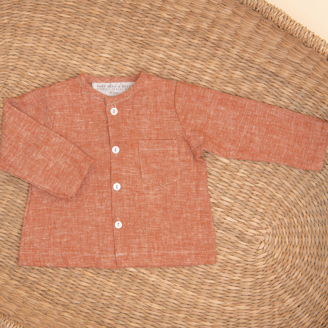 Flat lay photo of the clay colored Silas Linen Shirt in a woven basket
