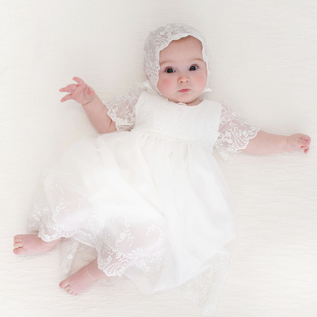 Baby girl wearing Ella Romper Dress and Bonnet.
