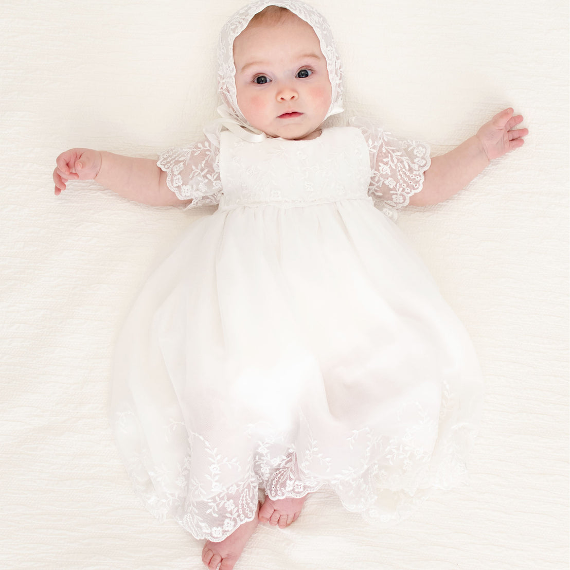 Baby girl wearing the Ella Romper Dress with Ella Lace Bonnet.