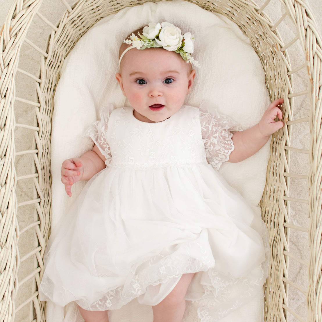 Baby girl wearing Ella romper dress with an Ella Flower Headband.