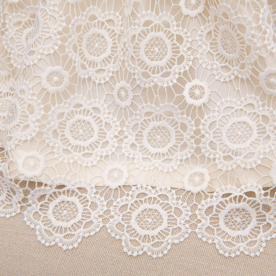 Product detail of the see-through hem of the Poppy lace christening dress.