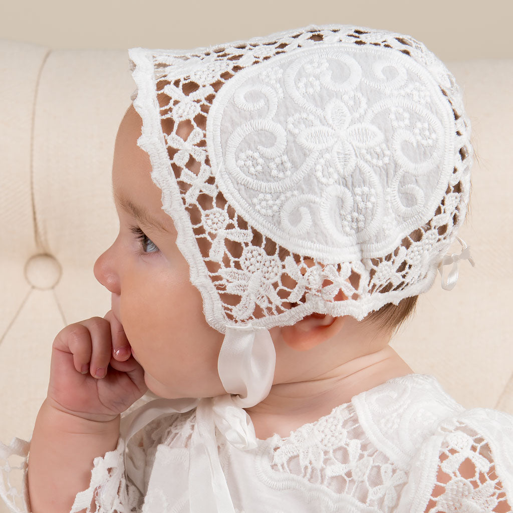Baby girl profile photo wearing a lace bonnet made of white textured cotton. 