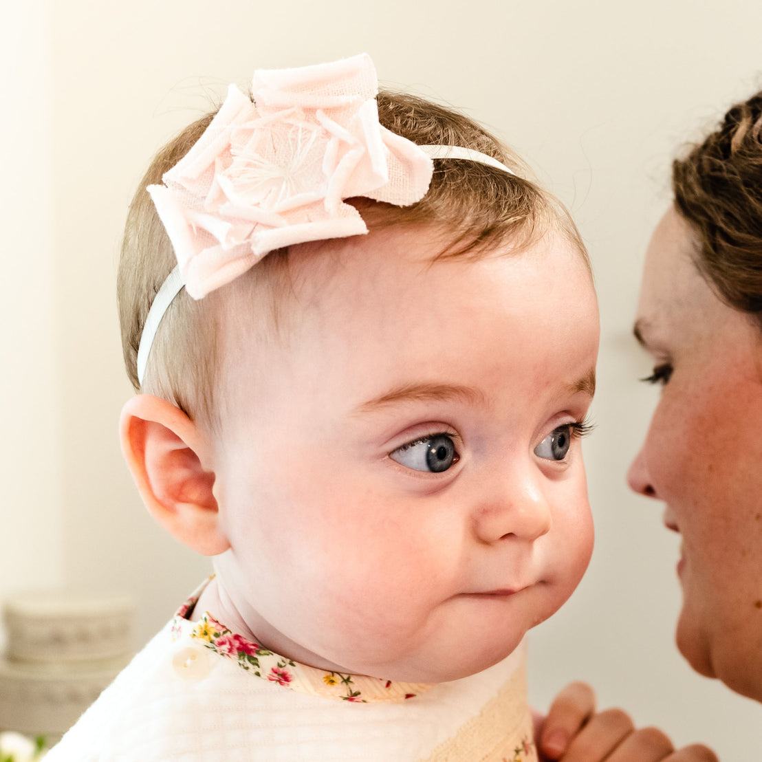 Newborn baby girl wearing the light pink Eloise Linen Flower Headband.