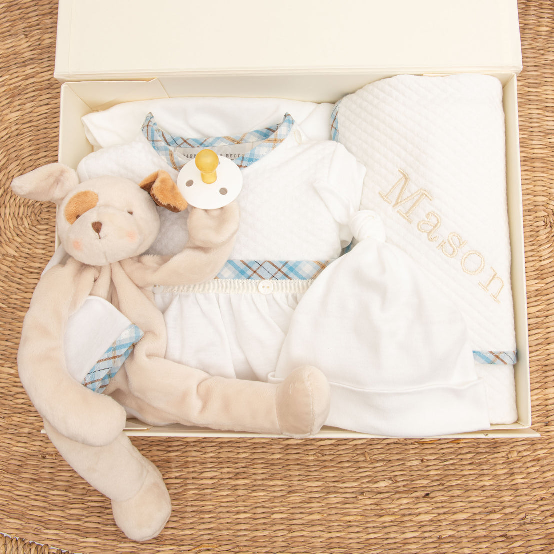 An upscale Mason Newborn Gift Set containing a plush bunny, a pacifier, a white onesie with plaid detailing, and a personalized heirloom white personalized blanket embroidered with the name "Mason".