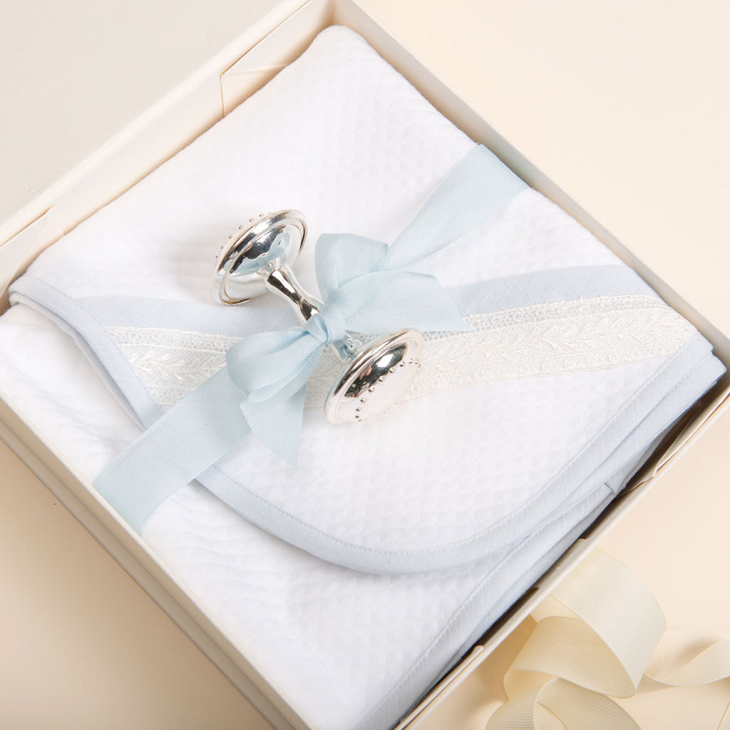 A Baby Beau & Belle gift set containing a white lace-trimmed handkerchief tied with a pale blue ribbon and silver plated baby rattles in a cream-colored Ivory Gift Box with magnetic closure.