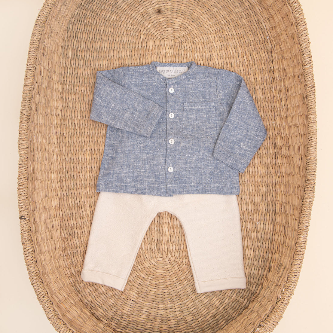 Flat lay photo of the blue Silas Linen Shirt Set. It includes a linen collarless shirt paired with ivory french terry cotton pants