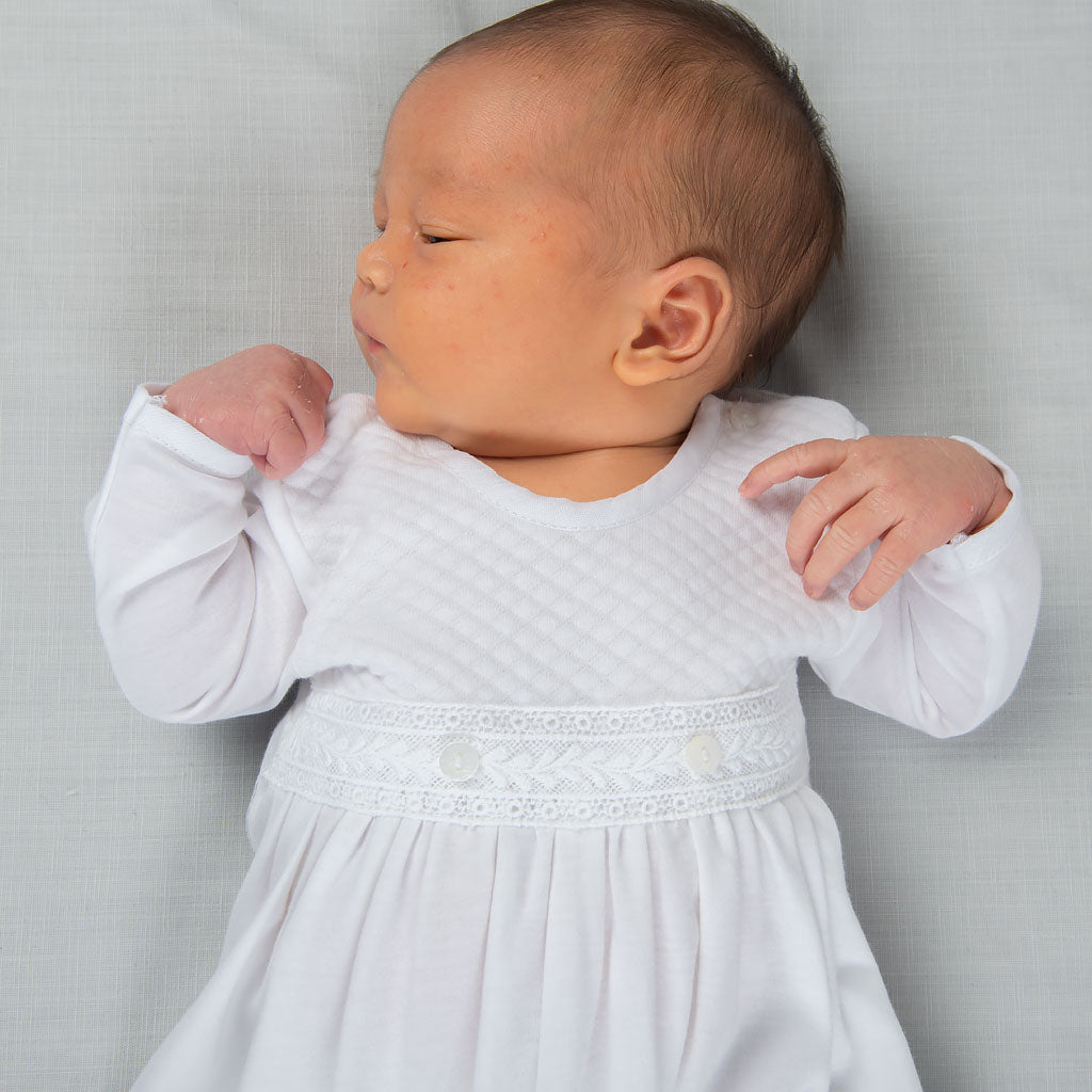 Close photo detail of newborn sleeping and wearing the Elijah Newborn Gown