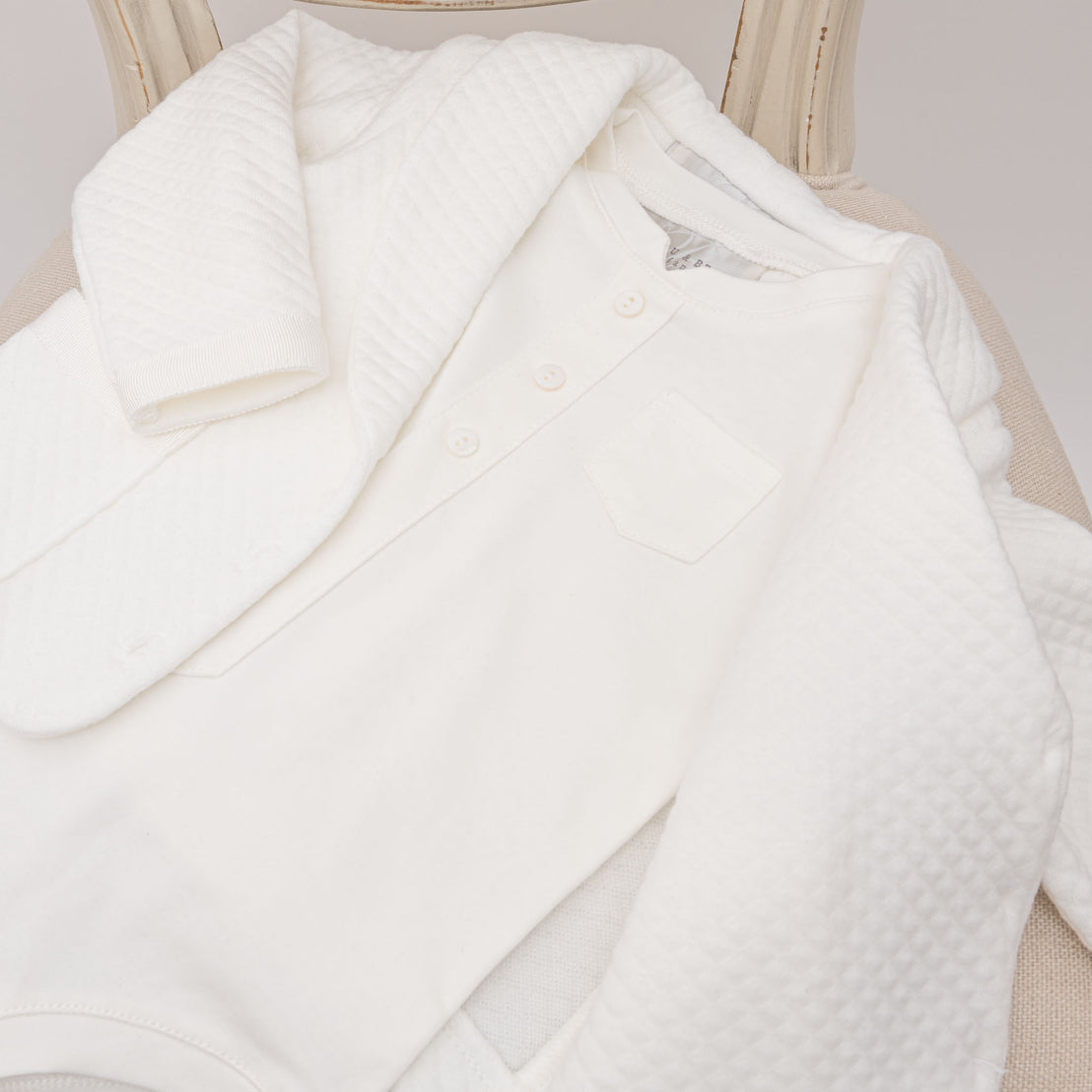 Flat lay photo of the Braden Jacket made out of quilted cotton and the white cotton onesie shirt
