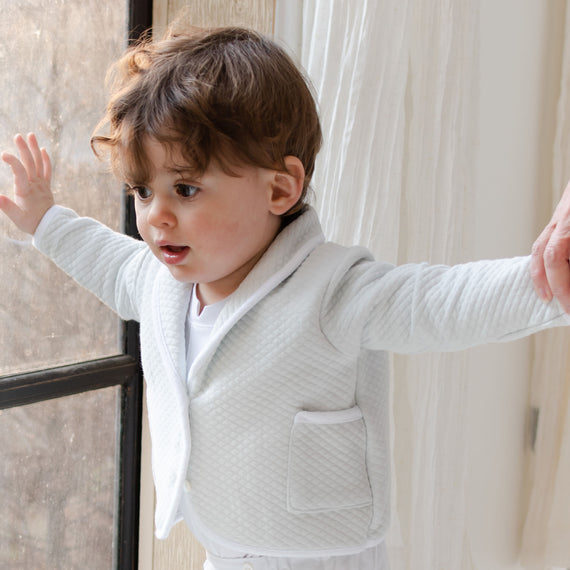 The Asher Soft Teal 3-Piece Baby Boy Suit. Baby boy wearing suit standing by window. 