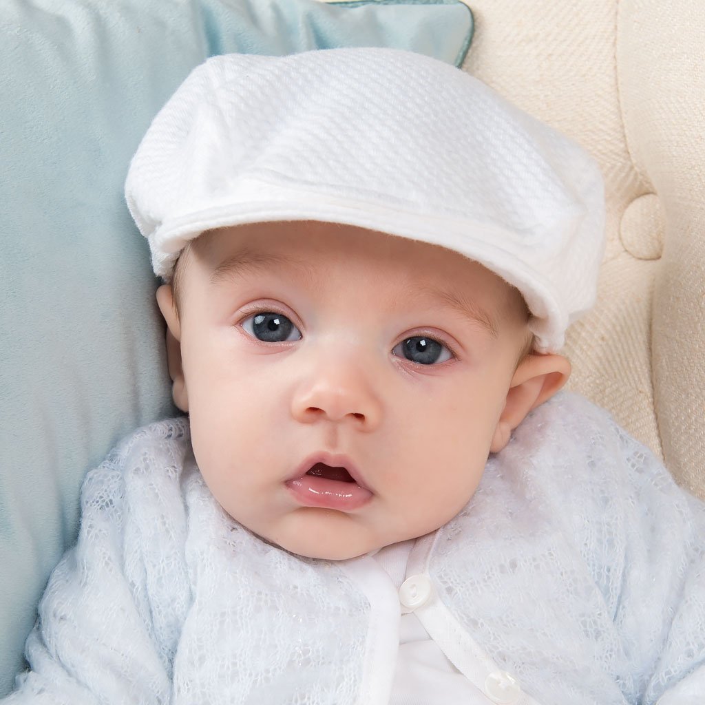 Baby boy wearing the Harrison Textured Newsboy Cap made with the same textured cotton. The newsboy style baby hat is finished with a soft elastic along the back to ensure a nice, comfortable fit