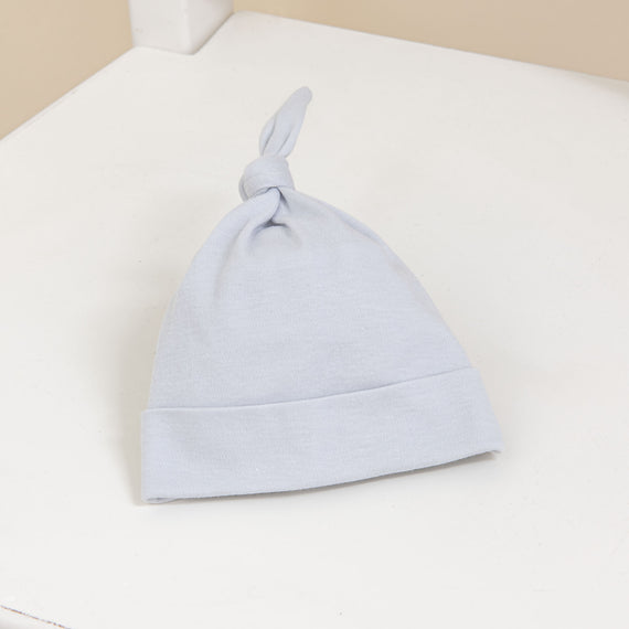 Flat lay photo of the Grayson newborn knot cap made of super soft cotton.