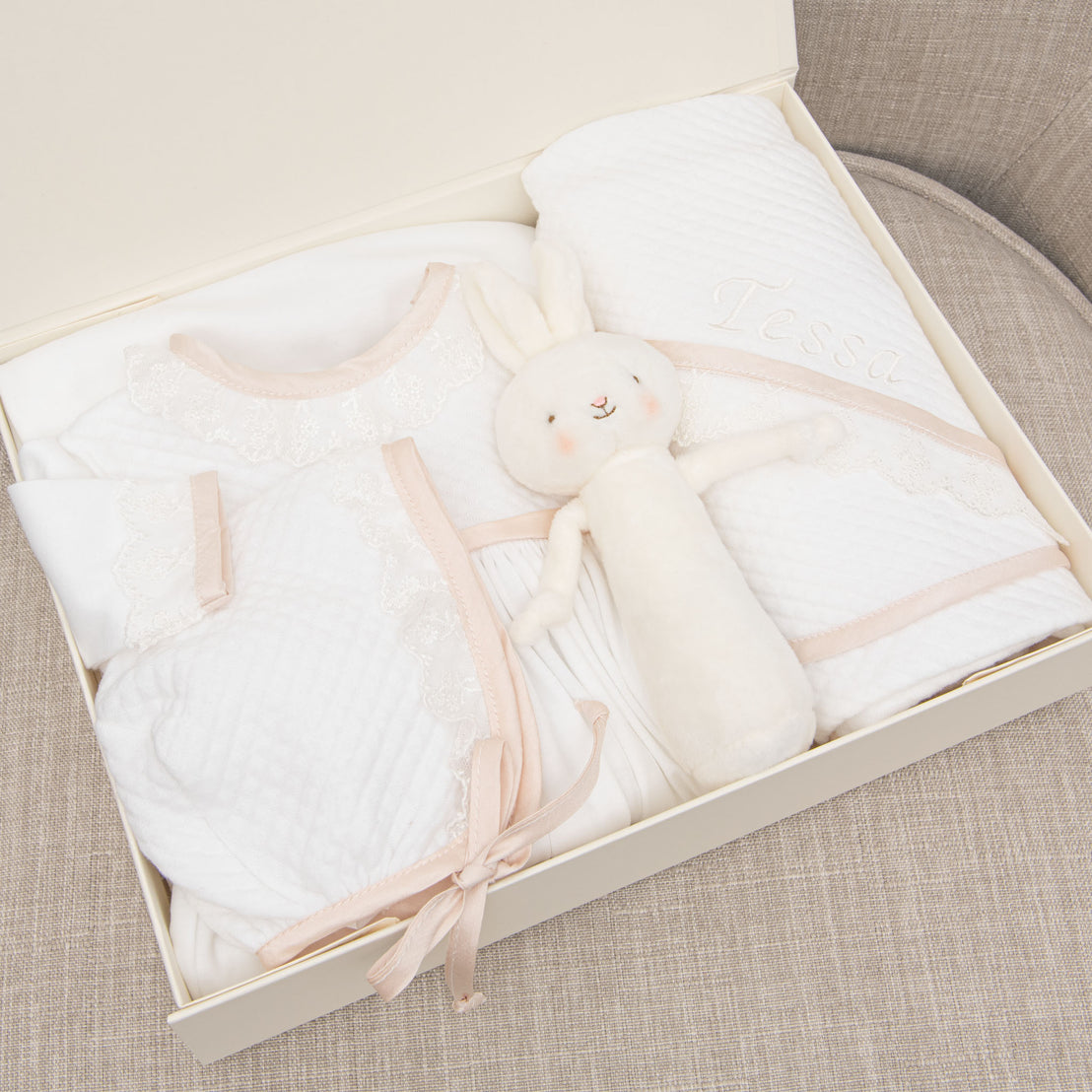 Photo showcasing what is in the Tessa Newborn Gift Set, including the Layette Gown, Bonnet, Bunny Chime, Blanket and Gift Box.