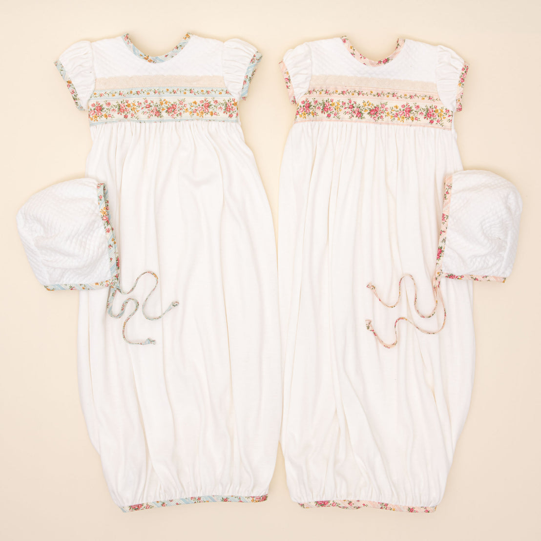 Flat lay photo comparison of the "Powder Blue" and "Blush" Eloise Layette Gown and Eloise Bonnet.
