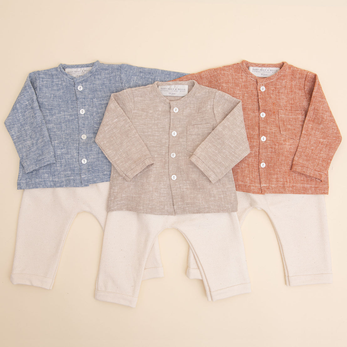 Flat lay photo of all three colors of the Silas Linen Shirt Set, including the colors blue, tan, and red. The set includes a linen collarless shirt paired with ivory french terry cotton pants