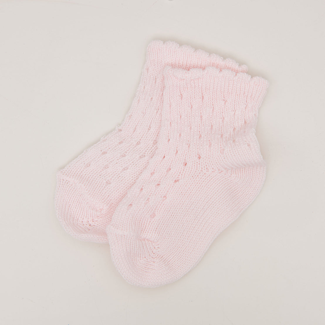 A pair of light pink Scallop Edge Crochet Socks with a delicate pattern, displayed flat on a white background.