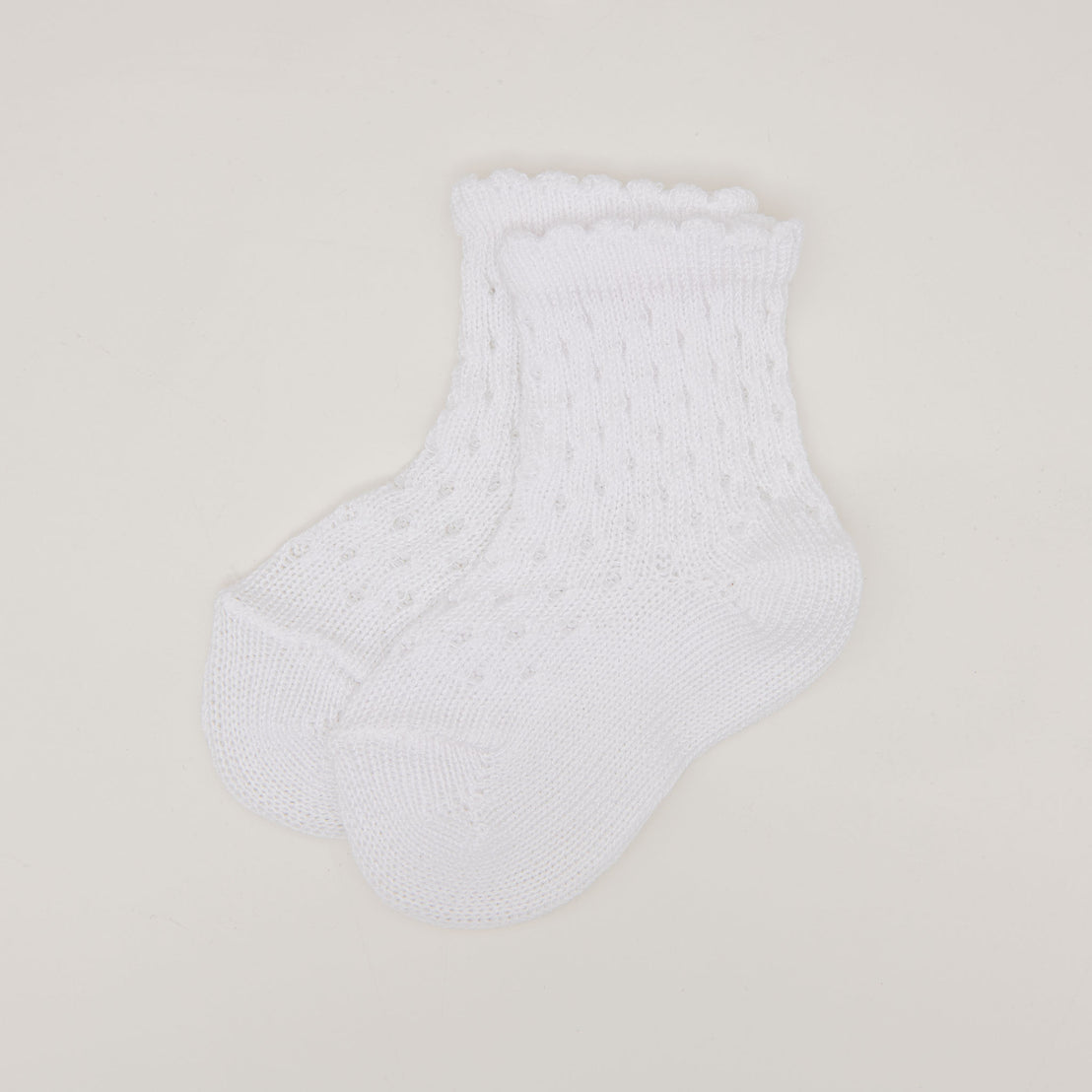 A pair of white Scallop Edge Crochet Socks with a delicate knit pattern and ribbed cuffs, displayed on a plain light background.