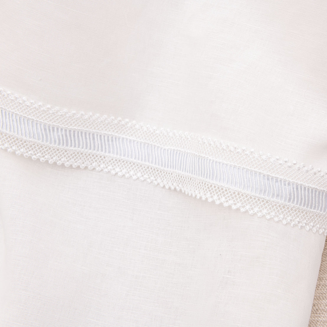 Close up detail of the hem of a linen boys baptism gown. 