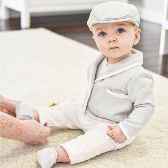 Baby boy wearing the Grayson grey baby boy 3-piece suit and newsboy cap.